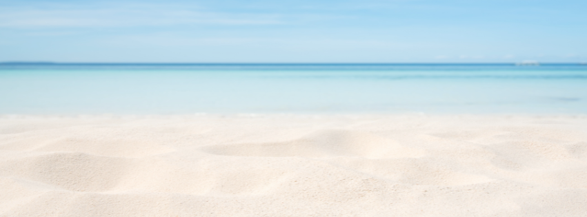 Sandy beach with blue water and a blue sky